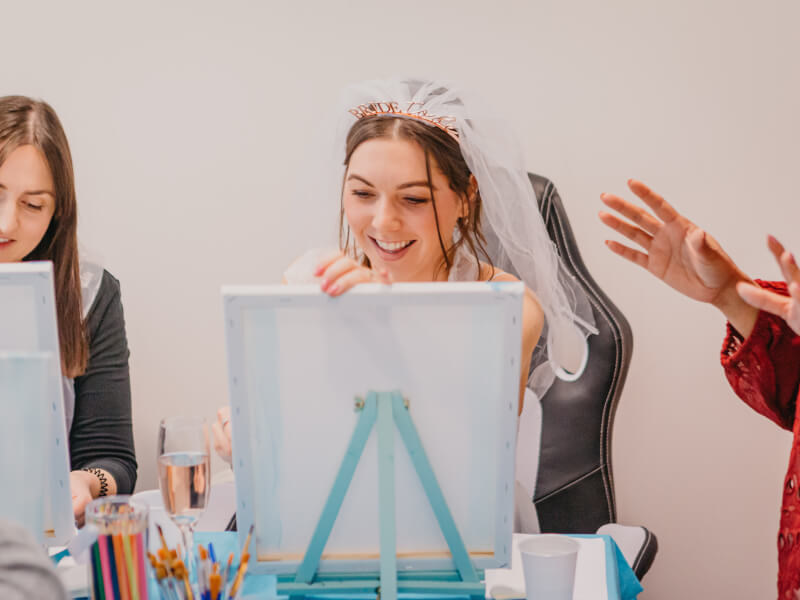 bride to be smiling at paint and sip